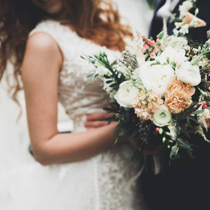 Digital Marketing Agency for Wedding Vendors 2 Close-up of bride holding a floral bouquet beside groom on wedding day—ideal for digital marketing agency for wedding vendors promoting services in the wedding industry.