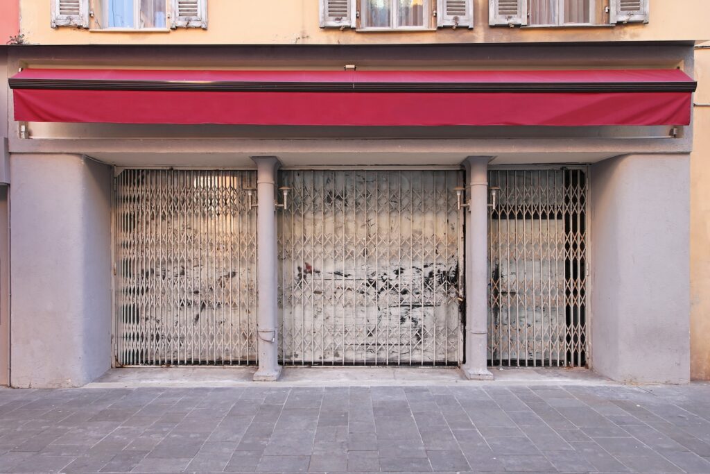 A closed retail storefront with a metal security gate, representing the decline of brands under private equity in home service marketing and retail sectors.