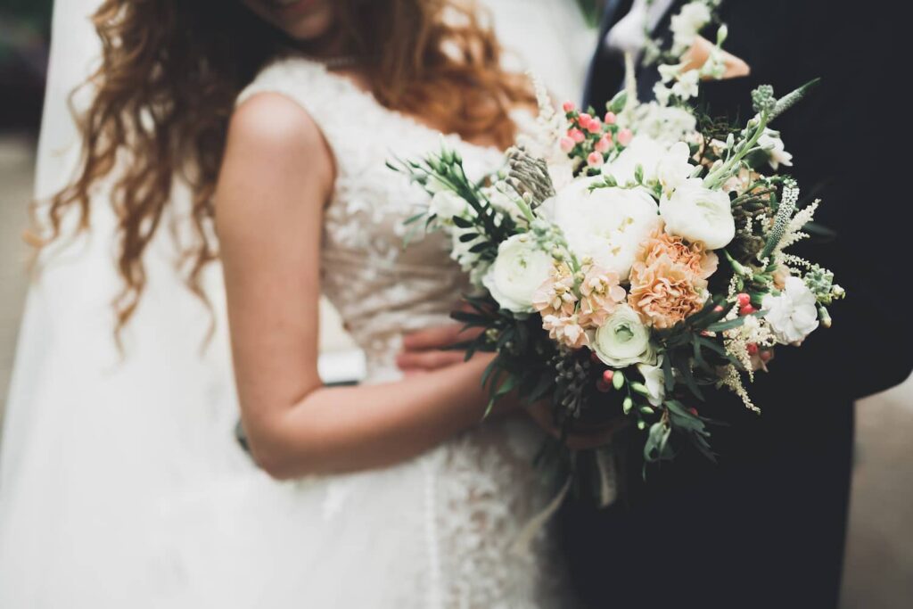 Bride holding a floral bouquet beside the groom