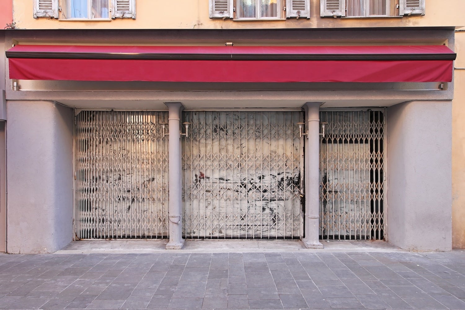A closed retail storefront with a metal security gate, representing the decline of brands under private equity in home service marketing and retail sectors.