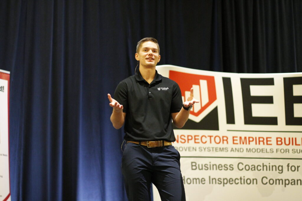 Aaron Shishilla of WolfPack Advising presenting on stage at an Inspector Empire Builder conference