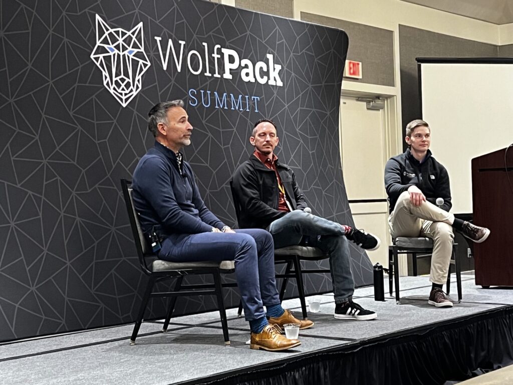 Three panelists on stage at WolfPack Summit
